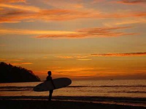 Surfer at Sunset in Guanacaste A longboard surfer watching the sunset in Guanacaste Province, in the northwest of Costa Rica.